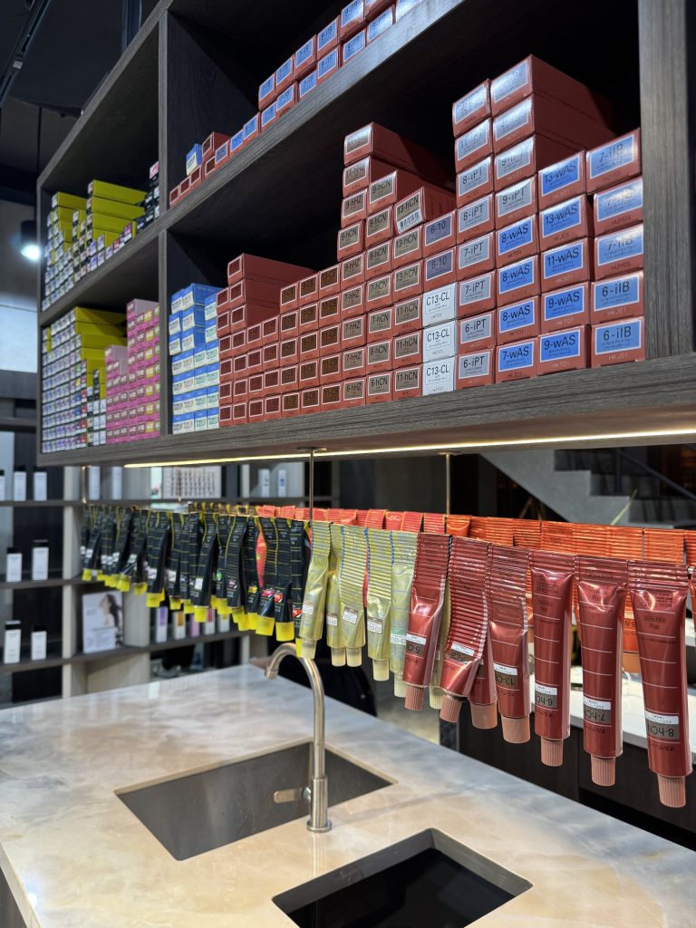 Shelves of hair color boxes above the mixing sink