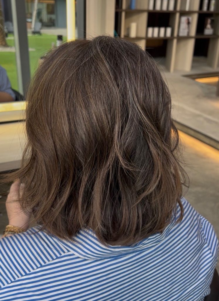 A wavy bob with soft brown grey blending, seen from behind