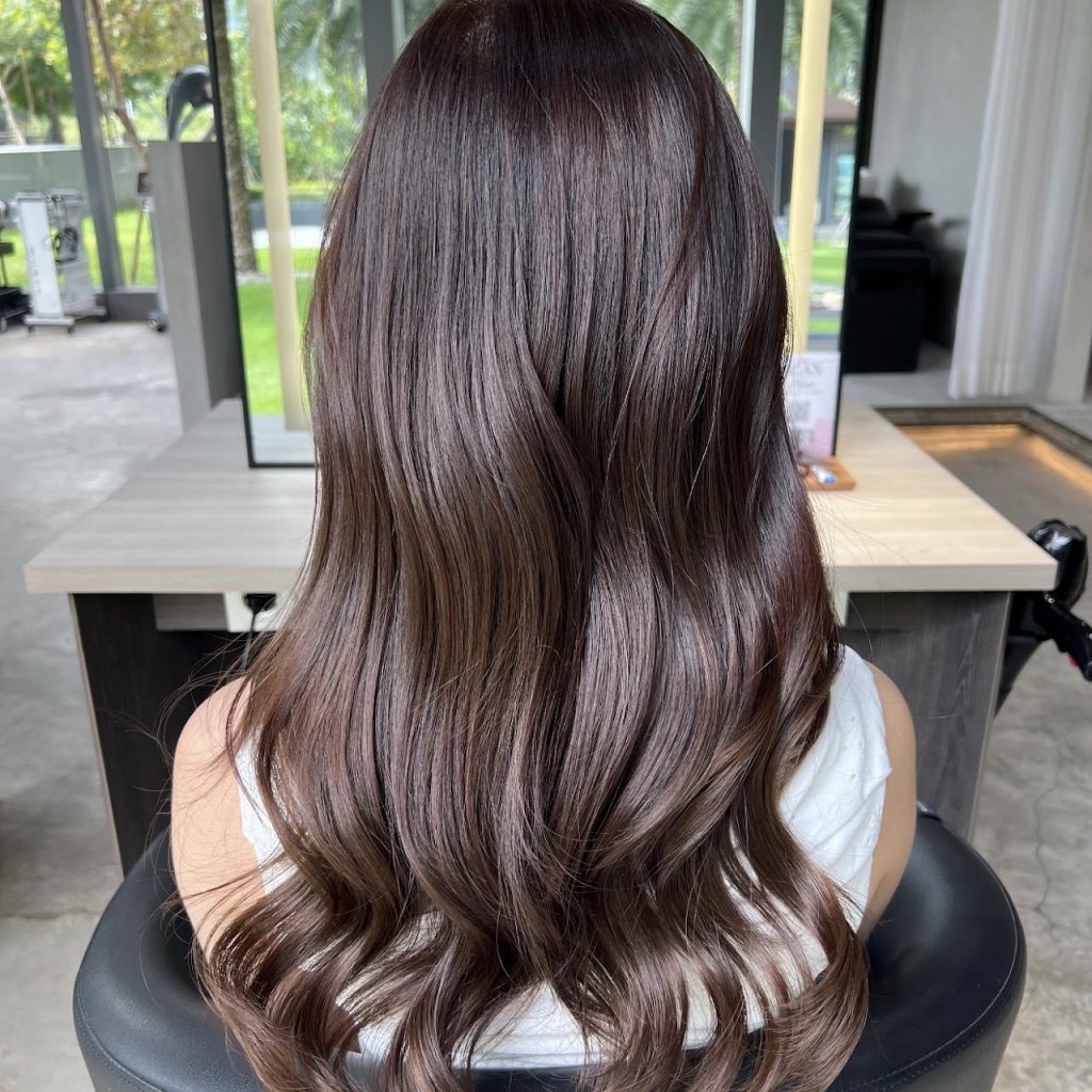 Long layered hair in a glossy mauve brown without bleach, seen from behind